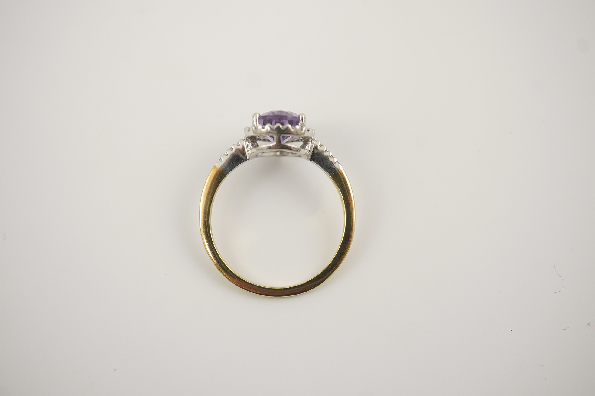 A modern 18ct gold and single stone pear cut amethyst set ring, with diamond chip set border and shoulders, size O, gross weight 3.4 grams. Condition - fair to good